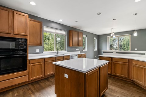 A kitchen with wooden cabinets and a white island.