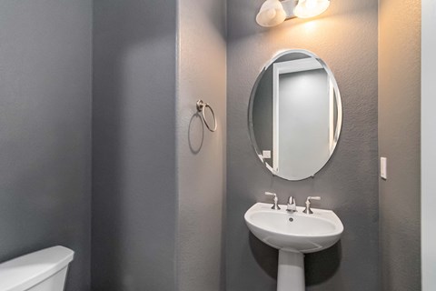 A bathroom with a sink, mirror and toilet.