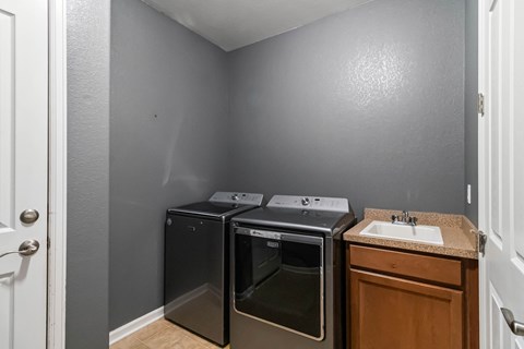 A small kitchen with a sink and two ovens.