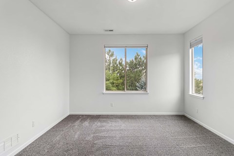 A room with a large window and a carpeted floor.