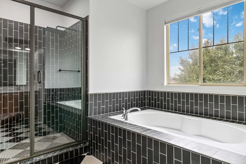 A bathroom with a white sink and a glass shower stall.