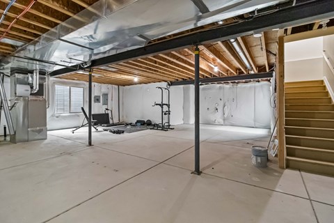 A room under construction with exposed ceiling beams and unfinished walls.