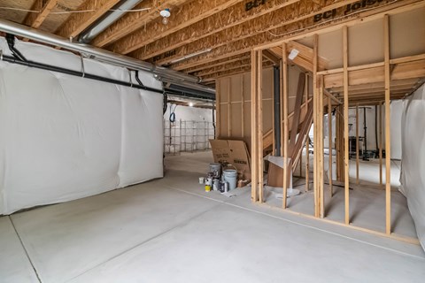 A room under construction with exposed wooden beams and insulation on the walls.