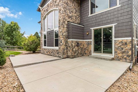 A house with a stone wall and a grey exterior.