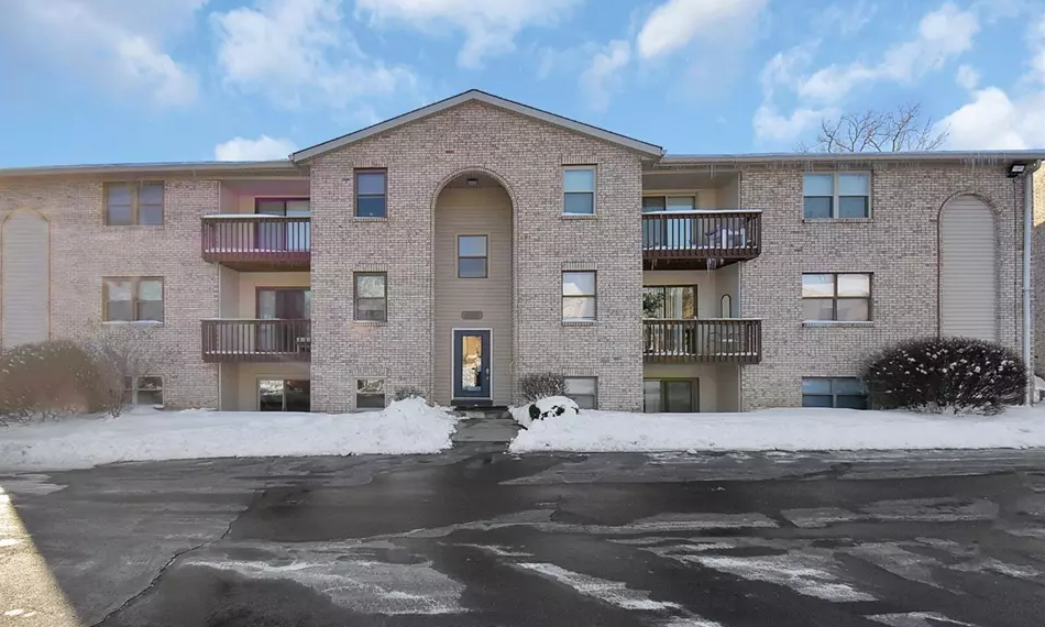 A large brick building with a parking lot in front.