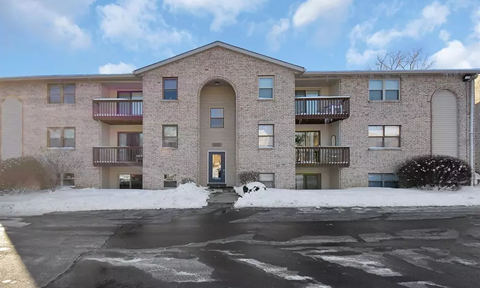 A large brick building with a parking lot in front.