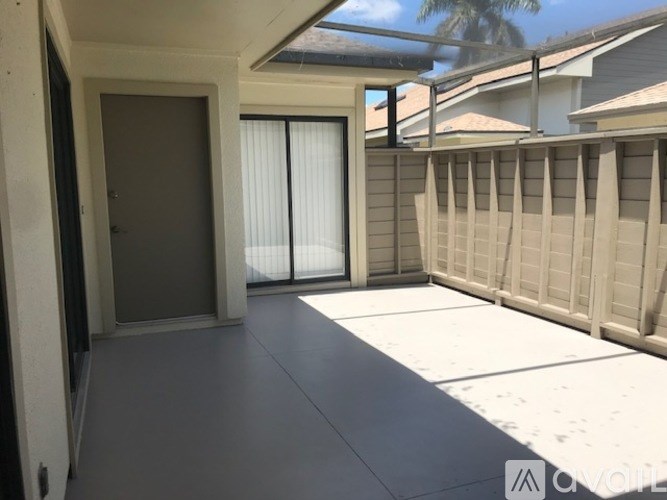 A sunny day in a residential area with a house and a fence.