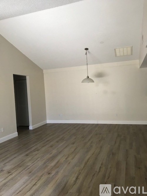 A room with wooden flooring and a light fixture.