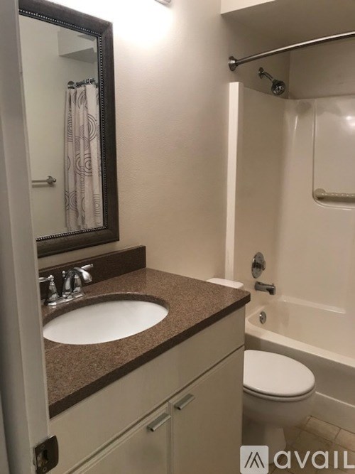 A bathroom with a brown countertop and a white toilet.