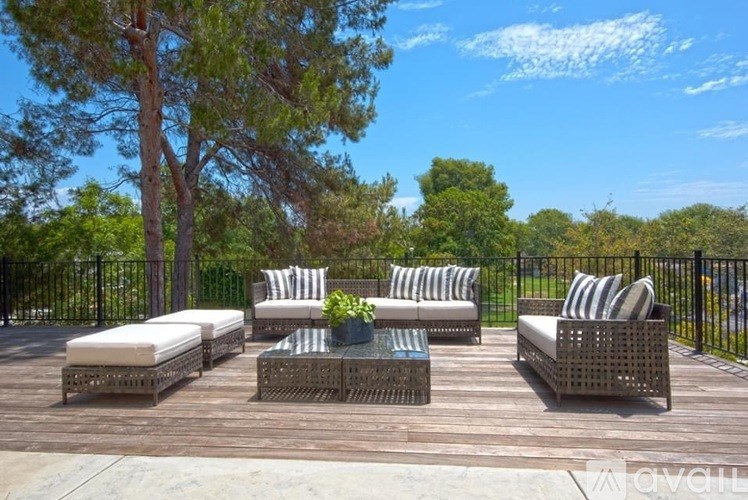 A set of outdoor furniture is arranged on a wooden deck.