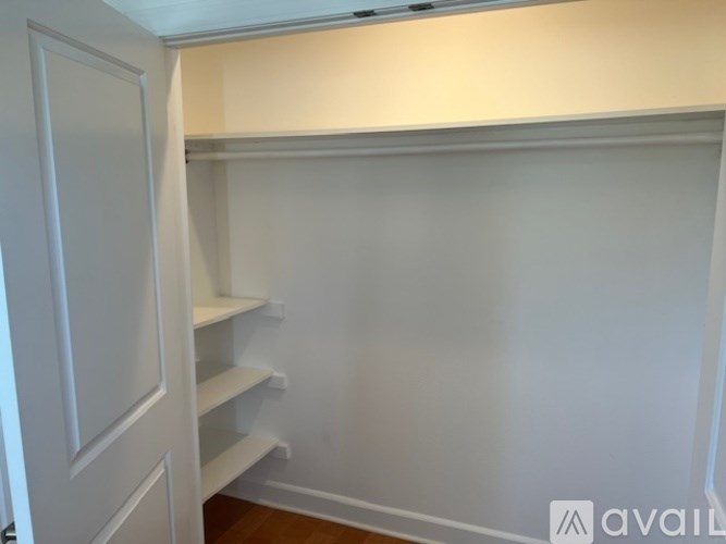 A white pantry with shelves and a door.