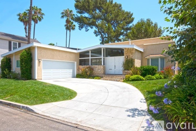 A house with a driveway and a garage is for sale.
