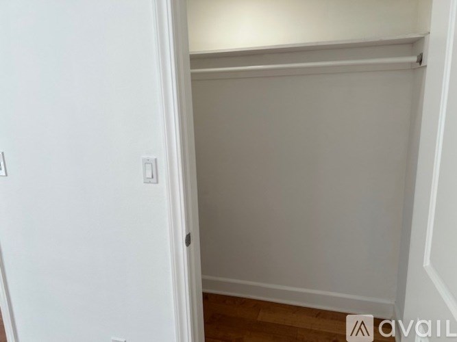 A white door with a light switch on the wall.