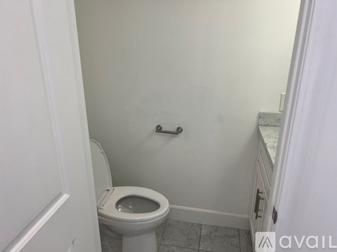 A white toilet in a small bathroom.
