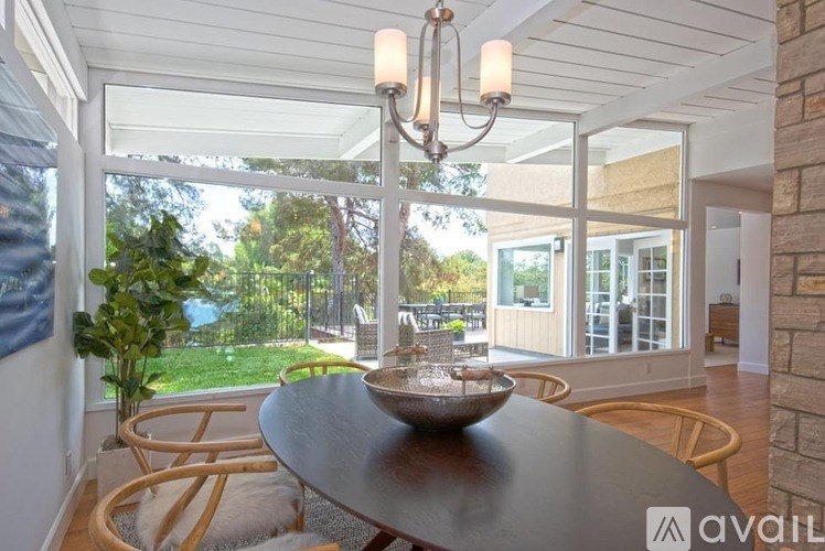 A dining room with a table set for two and a chandelier.