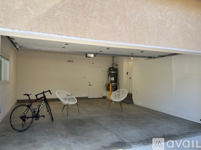 A garage with a bicycle and two chairs.