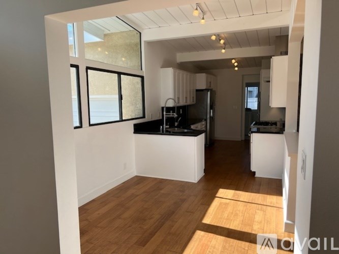 A kitchen with a black countertop and white cabinets.