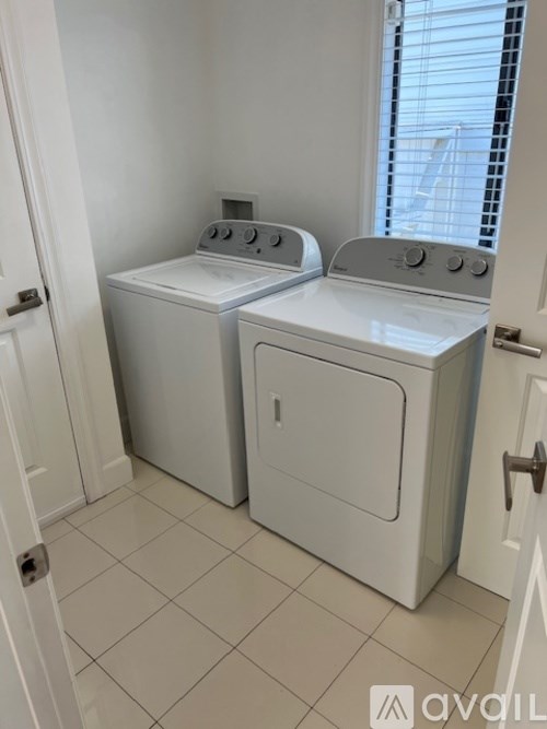 A white washer and dryer in a small laundry room.
