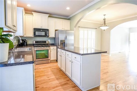 A kitchen with white cabinets and a black countertop.