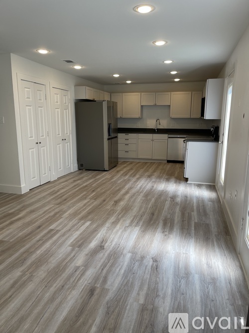 A kitchen with a refrigerator, cabinets, and a countertop.