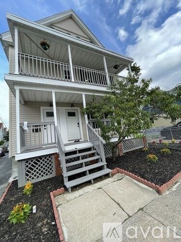 A two-story house with a front porch and a small front yard.