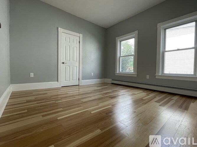 A room with wooden flooring and a white door.