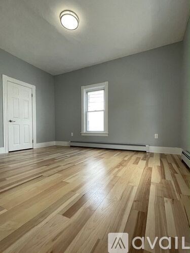 A room with wooden flooring and a window.