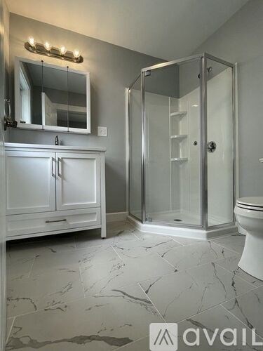 A bathroom with a marble floor and a white cabinet.