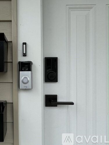 A white door with a black handle and a Ring video doorbell.