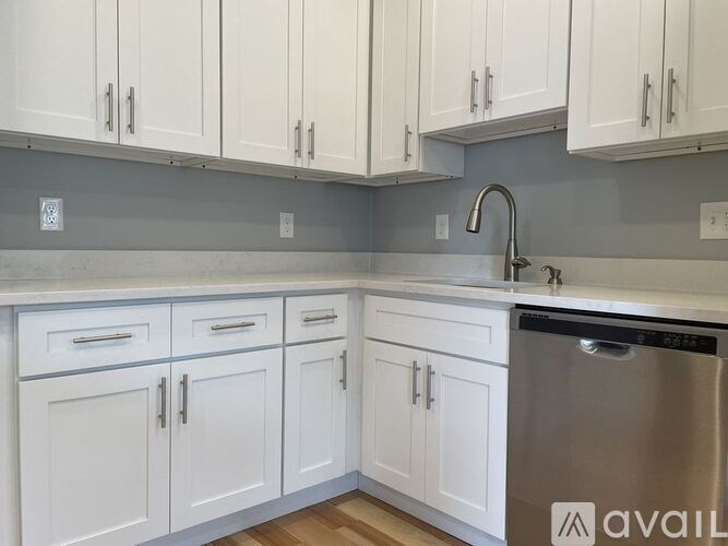 A kitchen with white cabinets and a stainless steel dishwasher.