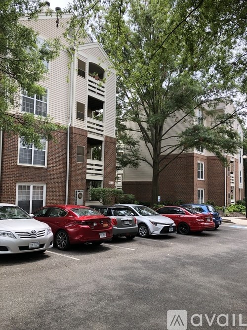 A parking lot with cars and apartment buildings.