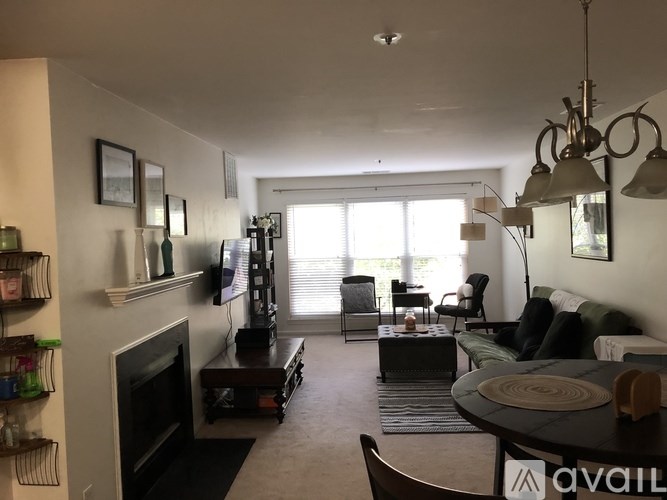 A living room with a fireplace, a couch, a chair, and a dining table.