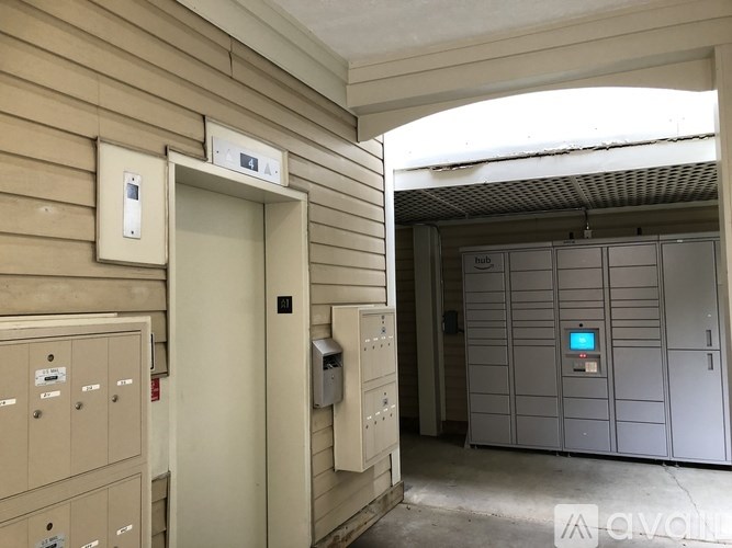 A hallway with a door and a wall-mounted control panel.