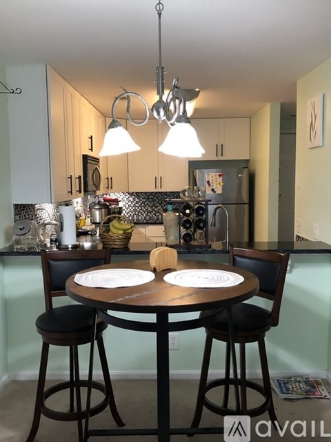 A kitchen with a table and chairs in the foreground.