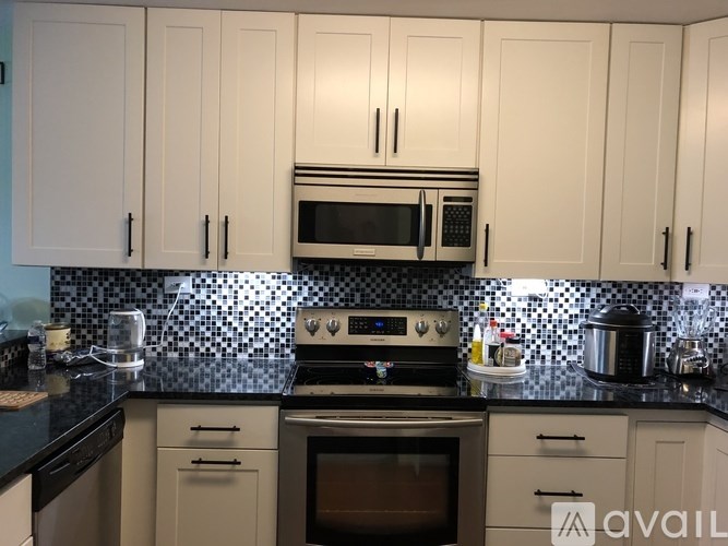 A kitchen with black countertops and white cabinets.
