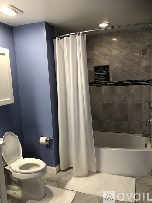 A white toilet sits in a bathroom with blue walls.