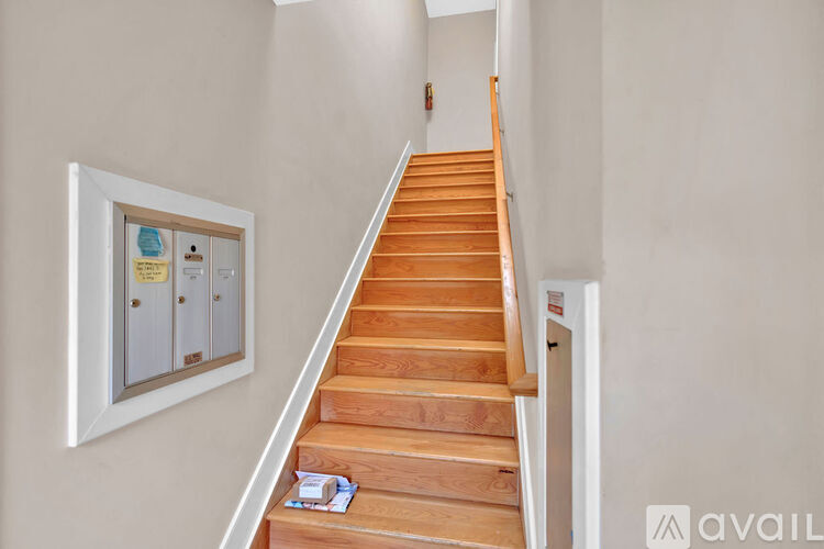 A room with a white ceiling and a painting hanging on the wall.