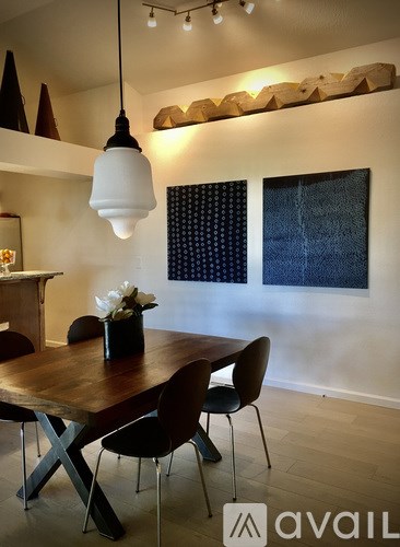 A dining room with a wooden table and chairs.