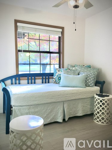 A bedroom with a bed, pillows, and a window.