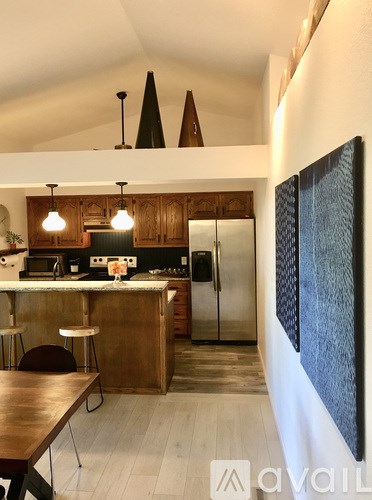 A kitchen with a wooden counter and a refrigerator.