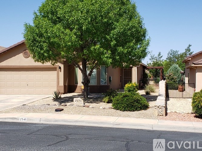 A house with a tree in front and a sign that says "AVAIL" on the front lawn.