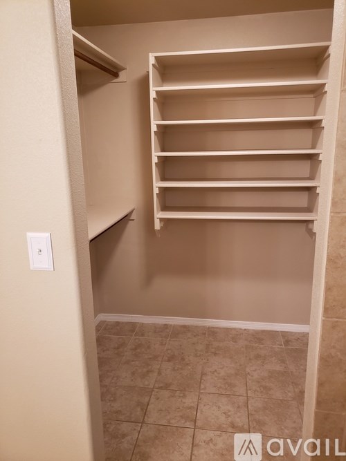 Empty white shelves in a room with beige walls and floor.