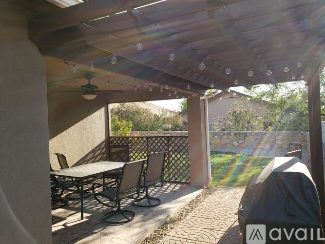 A patio with a table and chairs under a roof.