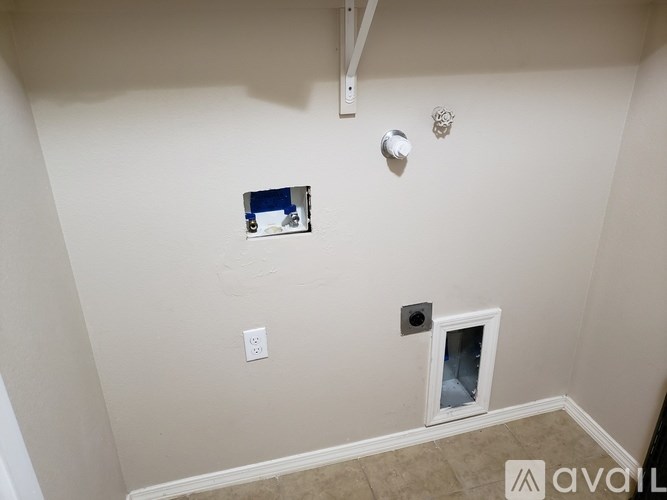 A room with a white wall and a small window.