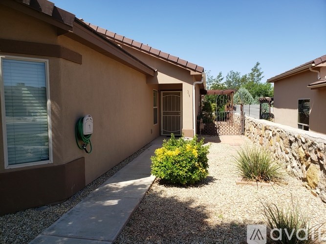 A house with a brown exterior and a stone wall in the front yard.