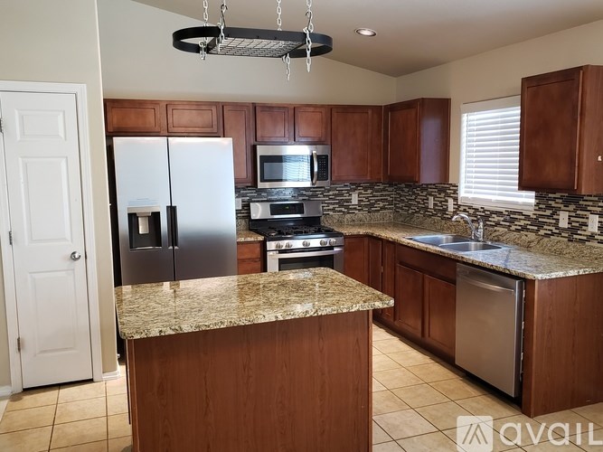 A kitchen with wooden cabinets and a granite countertop.