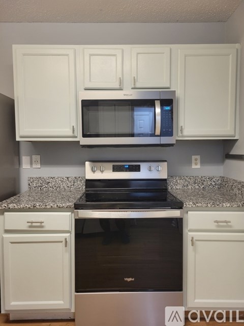 A kitchen with white cabinets and a black stove top oven.