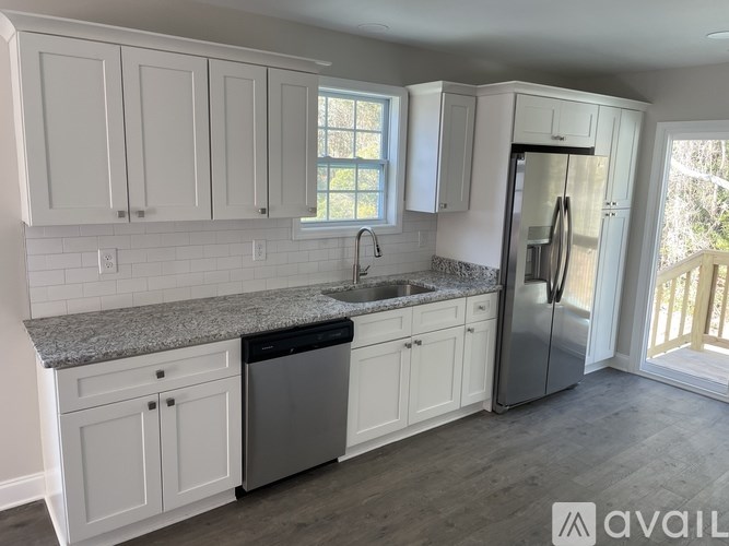 A kitchen with white cabinets and a granite countertop.