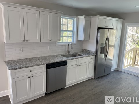A kitchen with white cabinets and a granite countertop.