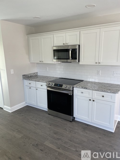 A kitchen with white cabinets and a black oven.